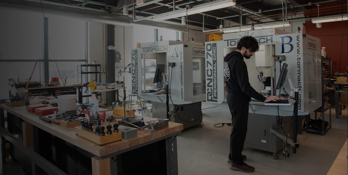 Person operating a CNC machine in a high-tech workshop.